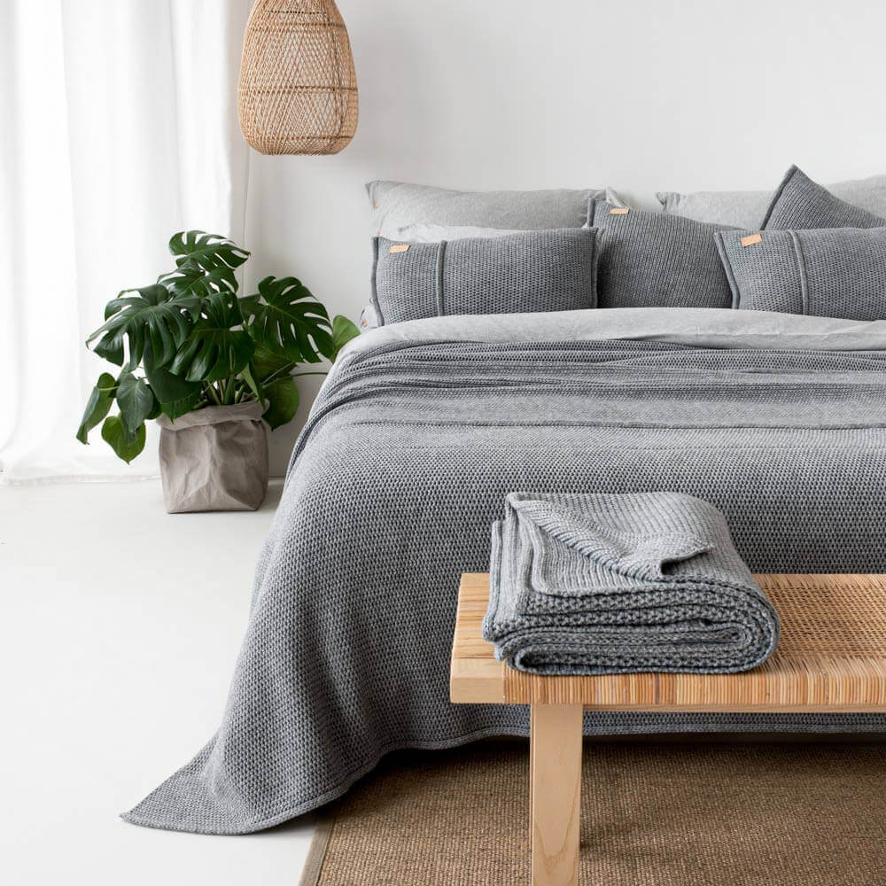 сива спалня с килими и възглавници